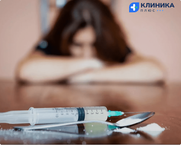 Девушка смотрит на шприц