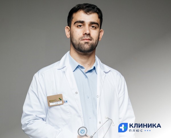 Врач в белом халате на тёмном фоне